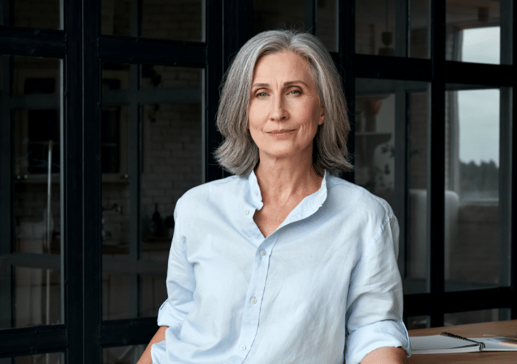 Confident stylish european mature middle aged woman standing at workplace. Stylish older senior businesswoman, 60s gray-haired lady executive leader m@2x